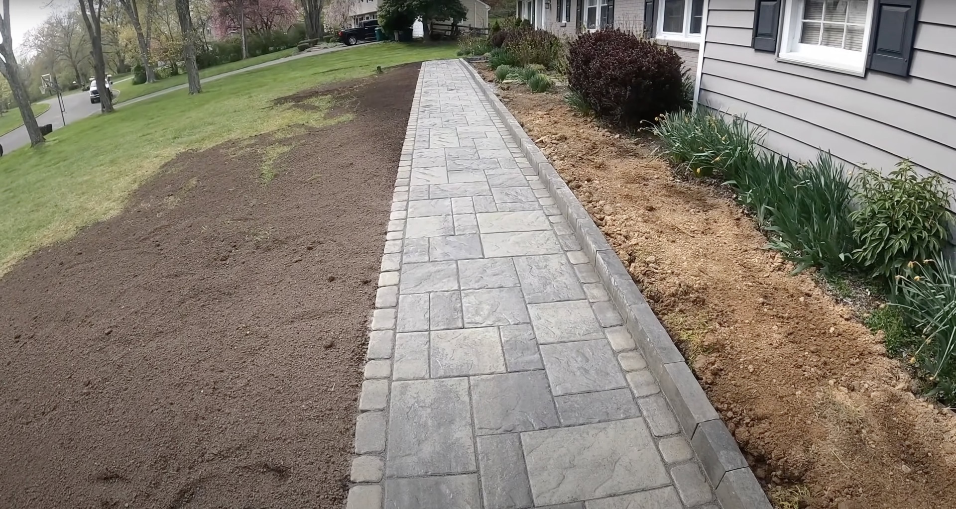 Decorative stamped concrete walkway installed by Burien Concrete professionals Beautiful stamped concrete walkway with decorative pattern in residential setting