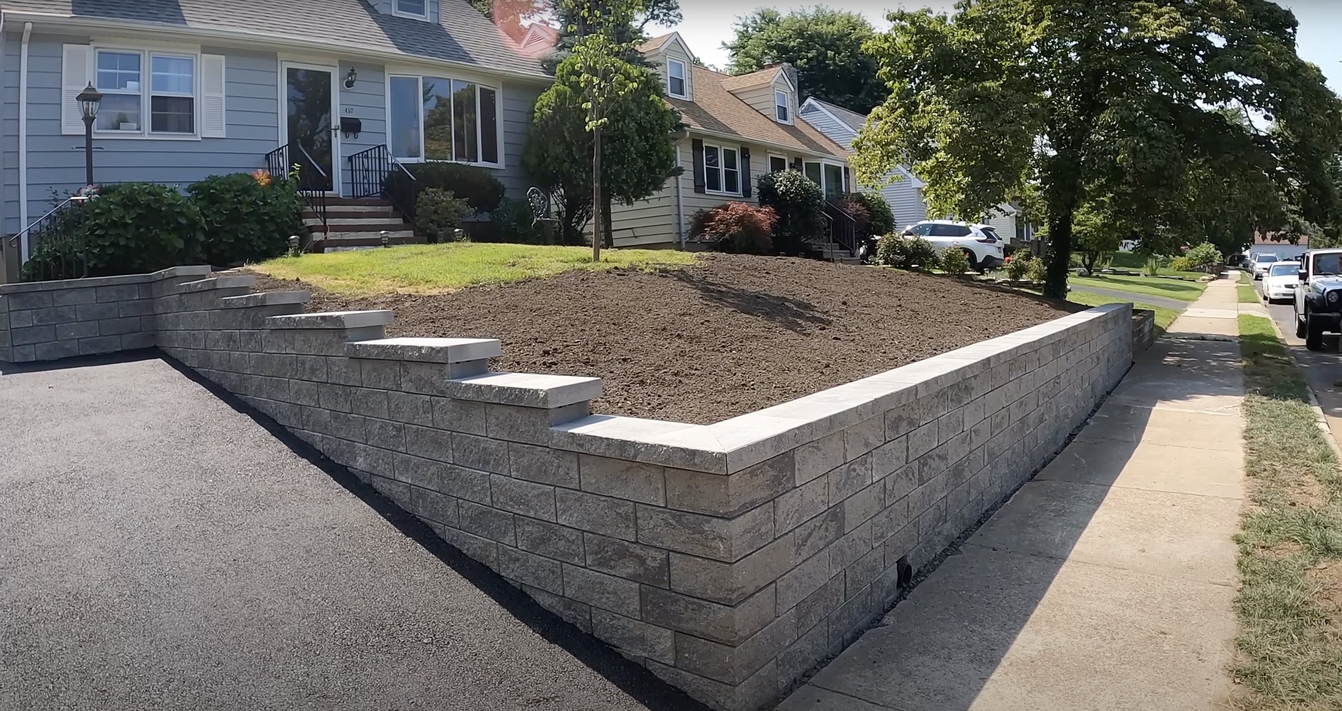 Concrete retaining wall installation by Burien Concrete - structural landscaping solution Professional concrete retaining wall construction with precise block placement in residential Burien neighborhood