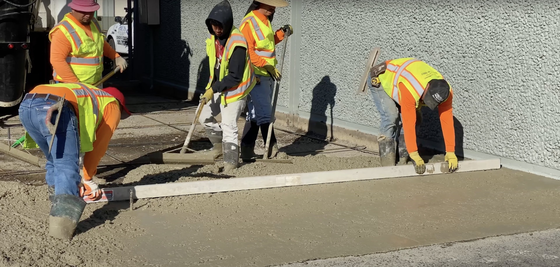 Concrete surface finishing techniques - expert craftsmanship by Burien Concrete team Professional concrete finishing crew using screeds and hand tools for smooth surface completion